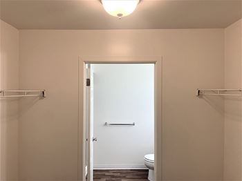 a small bathroom with a toilet and a white door at Windsor Place, Davison, MI